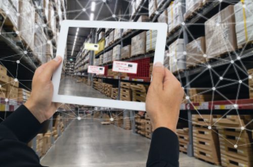 person with mobile device scanning items in a warehouse