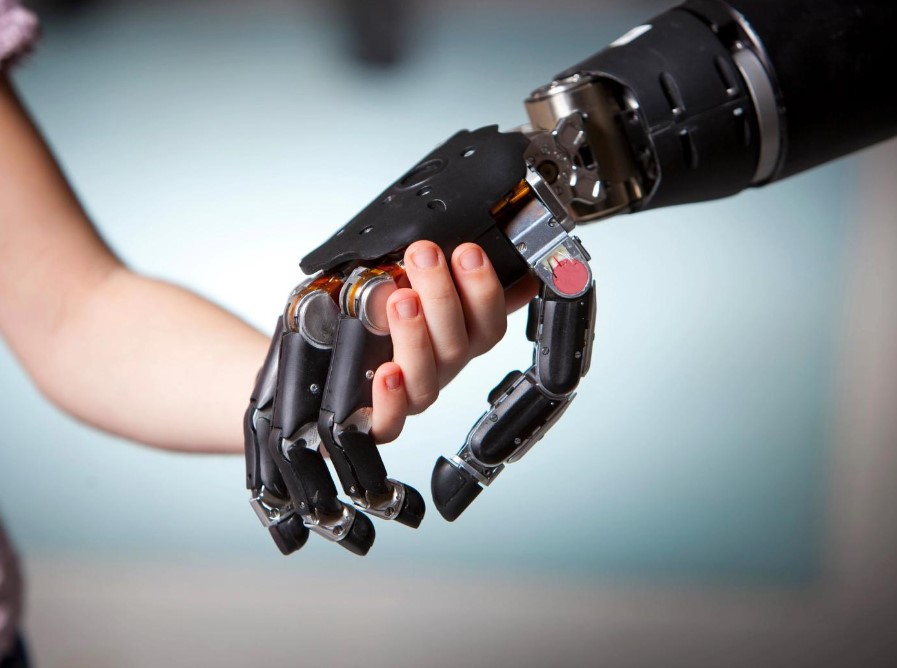 Figure 3 – Image of an adult and a child holding hands. The adult has a prosthetic hand (Modular Prosthetic Limb - ROBOTS: Your Guide to the World of Robotics, no date).